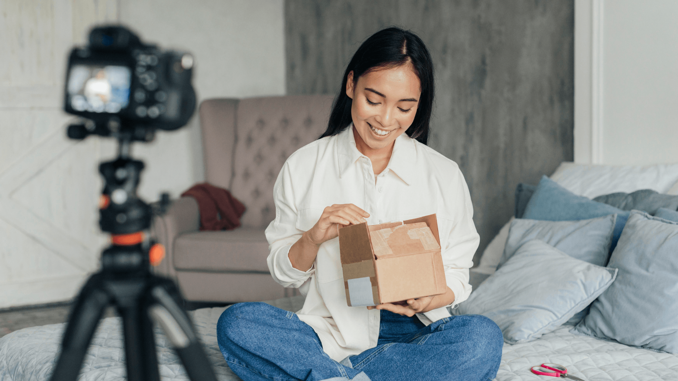 Creator filming an unboxing of a PR package at home, illustrating gifted products and influencer tax reporting for sponsored content.
