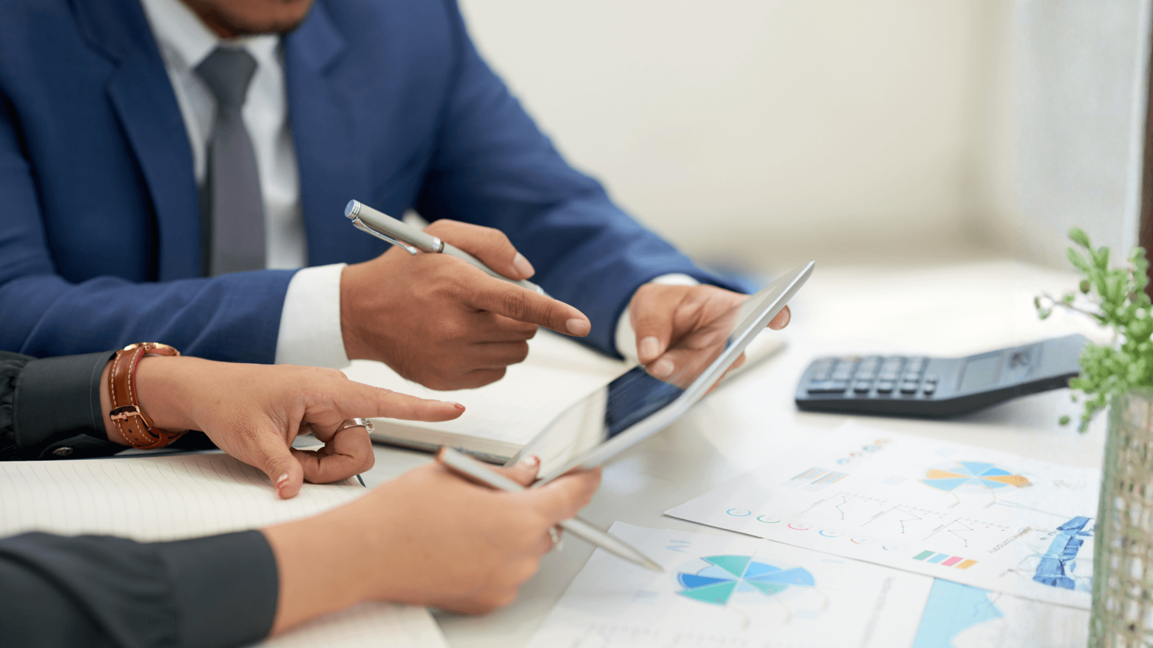 CPA firm team reviewing tax planning data and client advisory insights on a tablet during a strategy meeting.