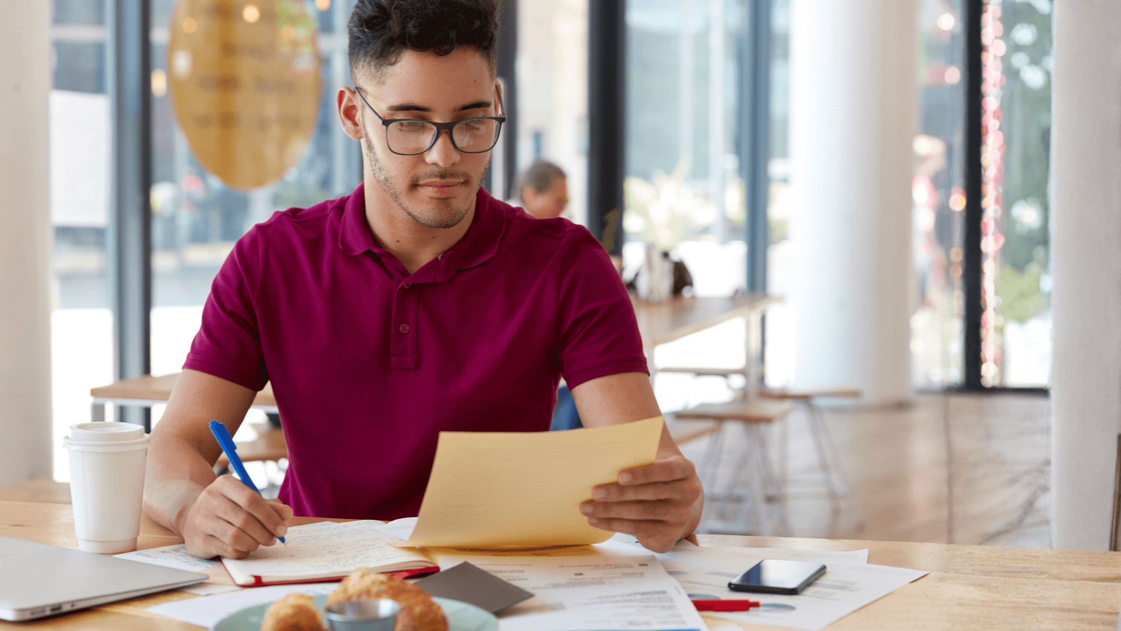 Freelancer reviewing estimated tax paperwork and income records at a desk while planning quarterly tax payments.