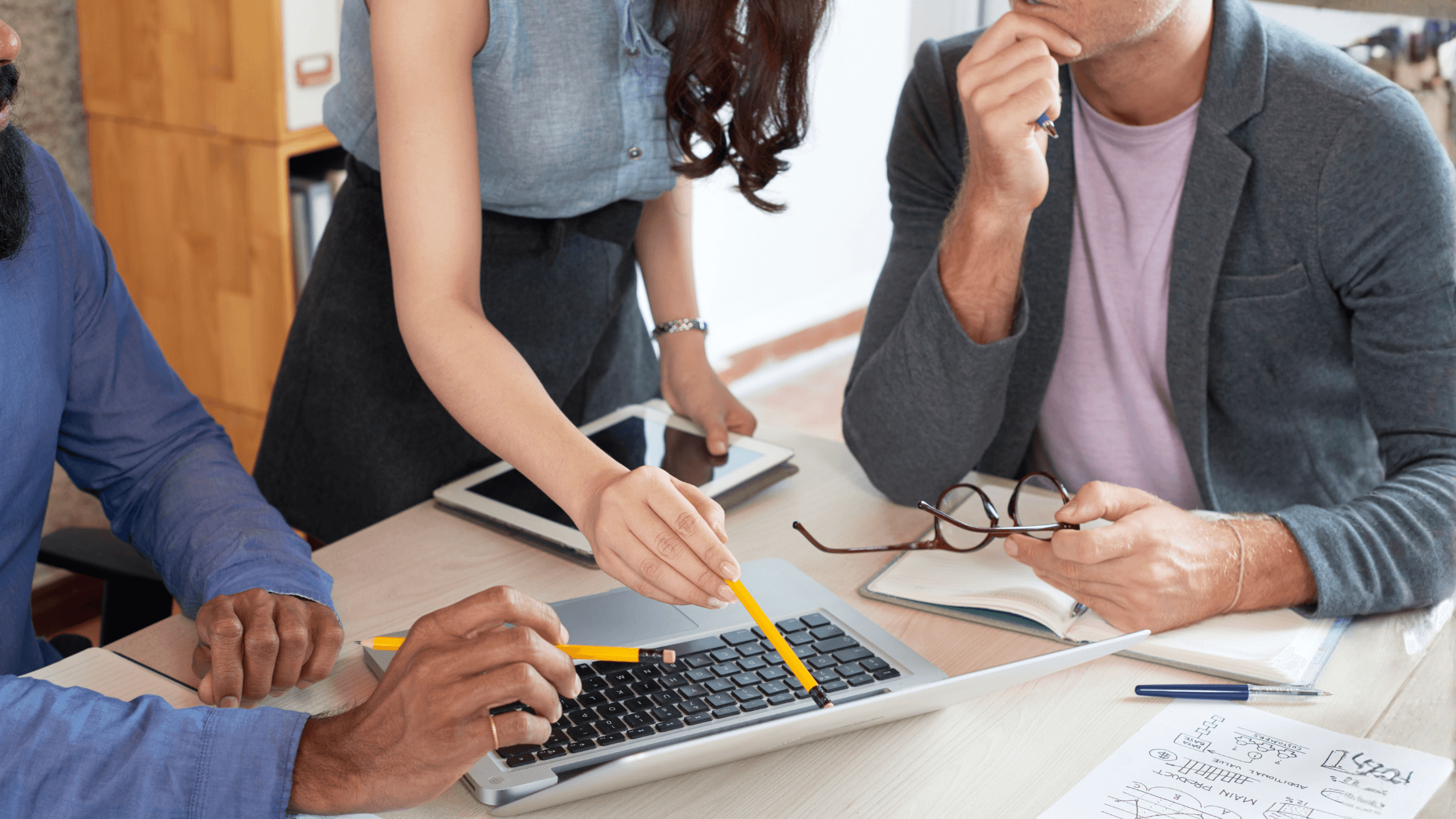Team reviewing laptop data and financial notes during a CPA firm advisory or tax planning strategy meeting.